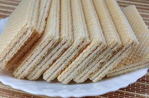 una pila de gofres crujientes está en un plato blanco. foto