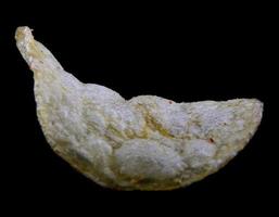 Crispy potato chips are isolated on a black background. photo