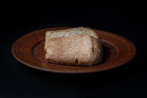 Sliced pieces of bread close-up on a ceramic plate. Sourdough bread. Side view . photo