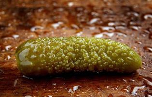 Pickled cucumber lies on a wooden cutting board. Pickles. Beautiful cucumbers. photo