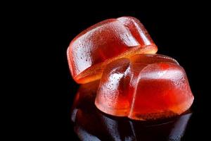 Beautiful marmalade candy with reflection isolated on a black background. photo