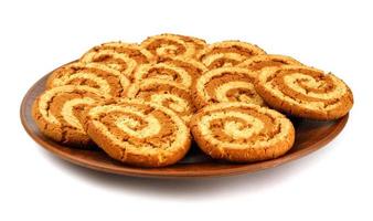 A clay plate with cookies is isolated on a white background. Cookies with a beautiful spiral pattern. photo