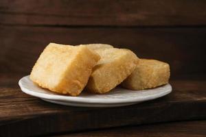 Jadah Goreng or Fried sticky rice cake is Javanese traditional cake made from glutinous rice and grated coconut. Served in white plate photo