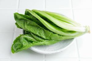 hojas de lechuga romana frescas y orgánicas aisladas en fondo blanco. imagen de enfoque selectivo foto