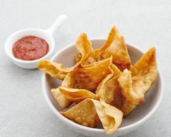 Pangsit, Pangsit Goreng, Delicious Pangsit Ayam Goreng, Chicken Fried Dumpling, Indonesian Traditional Food made from flour and chicken. Served with sauce photo