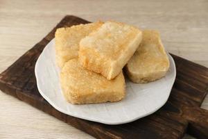 Jadah Goreng or Fried sticky rice cake is Javanese traditional cake made from glutinous rice and grated coconut. Served in white plate photo