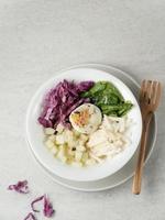 Salad bowl from green leaves mix vegetables, cabbage, lettuce, jicama, cucumber and egg with pineapple sauce. Served in bowl. Selective focus image. photo