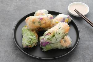 Vegetable spring roll, fresh roll salad made from mix vegetables and roasted chicken. Served in plate on dark concrete background. Selective focus image photo