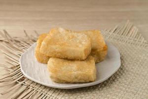 Jadah Goreng or Fried sticky rice cake is Javanese traditional cake made from glutinous rice and grated coconut. Served in white plate photo