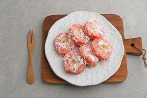 Kue Kacamata or Mata Roda is a traditional javanese snack. Bananas wrapped in cassava dough, steamed, covered with grated coconut. Similar to Sanggar Banyu, Putri Noong, Pisang Rai. photo