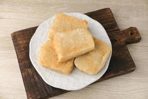 Jadah Goreng or Fried sticky rice cake is Javanese traditional cake made from glutinous rice and grated coconut. Served in white plate photo