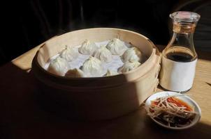 bola de masa hervida de sopa de shanghai al vapor en un tazón de bambú - xiao long bao ma foto