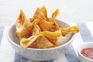 Pangsit, Pangsit Goreng, Delicious Pangsit Ayam Goreng, Chicken Fried Dumpling, Indonesian Traditional Food made from flour and chicken. Served with sauce photo