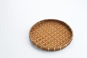 Traditional wicker plate made of bamboo isolated on a white background. Copy space. photo