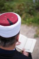 lectura del libro sagrado del corán por el imán en el funeral islámico foto