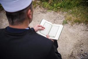 lectura del libro sagrado del corán por el imán en el funeral islámico foto