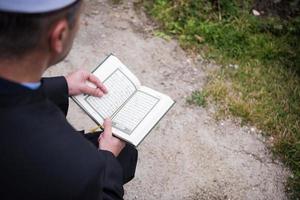 lectura del libro sagrado del corán por el imán en el funeral islámico foto