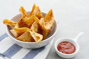 Pangsit, Pangsit Goreng, Delicious Pangsit Ayam Goreng, Chicken Fried Dumpling, Indonesian Traditional Food made from flour and chicken. Served with sauce photo