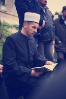 lectura del libro sagrado del corán por el imán en el funeral islámico foto