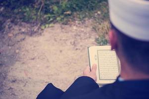 lectura del libro sagrado del corán por el imán en el funeral islámico foto