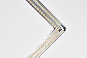 Tira de iluminación de lámparas LED con perfil de aluminio cuadrado en techo suspendido en casa, fragmento, cierre foto