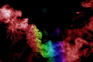 humo abstracto aislado sobre fondo negro, polvo de arco iris foto