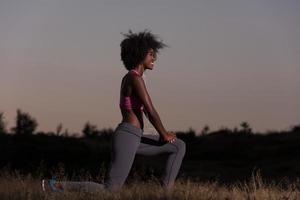 black woman is doing stretching exercise relaxing and warm up photo