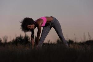 black woman is doing stretching exercise relaxing and warm up photo