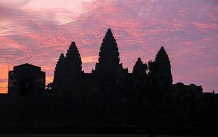 The silhouette of Angkor Wat before sunrise in Siem Reap province of Cambodia. Angkor Wat is an enormous Buddhist temple complex located in northern Cambodia. photo