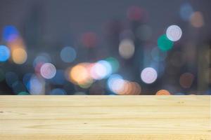 Empty wooden table with bokeh of light city background for product display photo