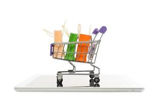 Shopping bag in a trolley with tablet on white background,Online shopping or ecommmerce concept photo