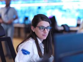 Female operator working in a security data system control room photo