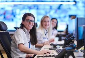 Female operator working in a security data system control room photo