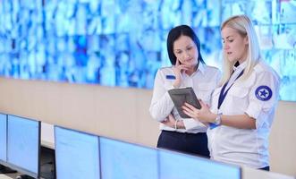 Female security guards working in a security data system control room photo