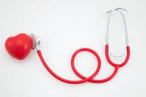 estetoscopio y corazón rojo sobre fondo blanco foto