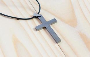 Necklace with silver cross on wooden table photo