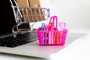 Mini shopping basket on laptop with Paper boxes in a trolley ,Online shopping or ecommmerce delivery service concept photo