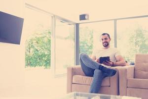 young man using a tablet at home photo