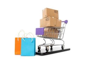 Paper boxes in a trolley with mobile phone on white background,Online shopping or ecommmerce concept photo