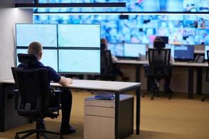 male operator working in a security data system control room photo