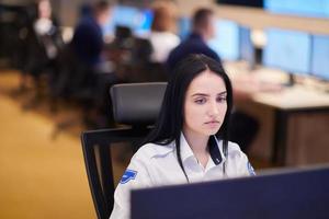 Female operator working in a security data system control room photo