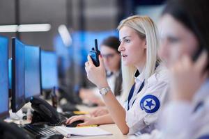 Female operator working in a security data system control room photo