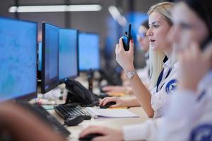 Female operator working in a security data system control room photo