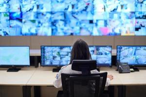 Female operator working in a security data system control room photo