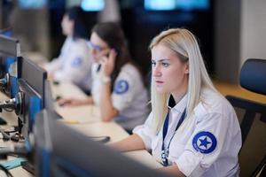 Female operator working in a security data system control room photo