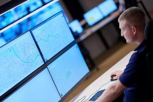 male operator working in a security data system control room photo
