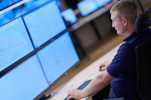 male operator working in a security data system control room photo