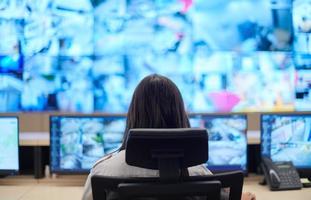 Female operator working in a security data system control room photo