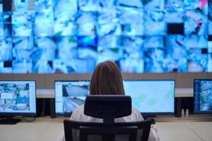 Female operator working in a security data system control room photo