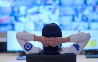 Female operator working in a security data system control room photo
